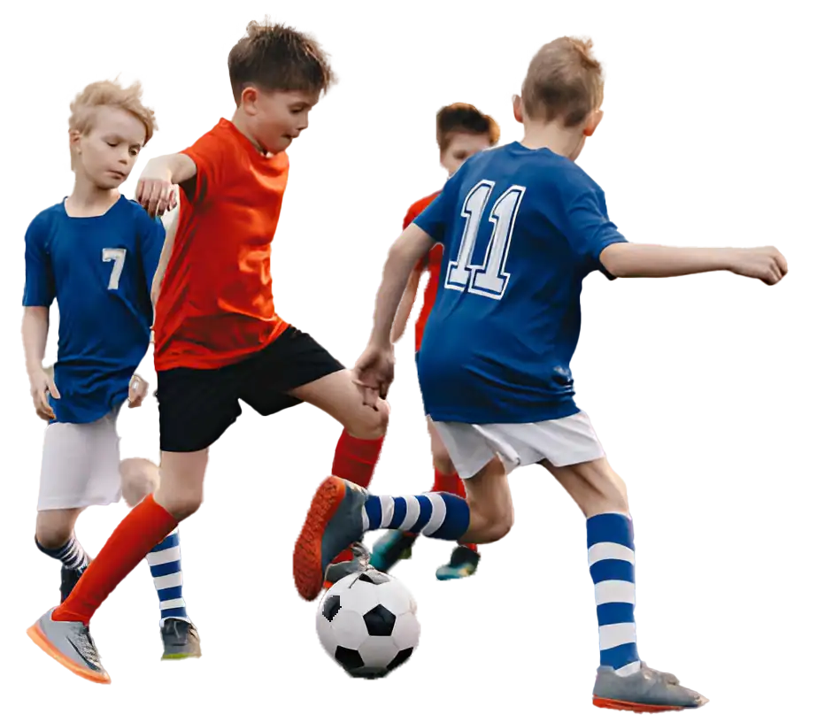 Niños jugando fútbol en un campo de deportes con camisetas de diferentes colores, demostrando actividad física y espíritu deportivo en una competencia juvenil.